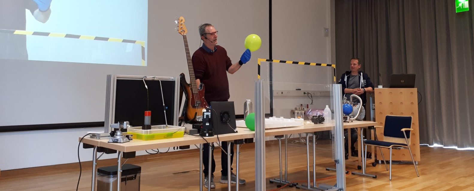 Zusehen ist der Physiker Torsten Kachel mit einem Luftballon in der Hand. Er wird in in flüssigen Stickstoff tauchen.